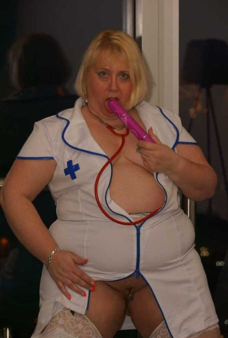 Obese blonde nurse Lexie Cummings uses a vibrator to stimulate herself while masturbating on a sofa.