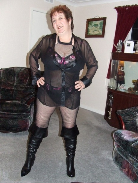 In a pair of BBW's adult models, she wears crotchless pantyhose and leather boots.