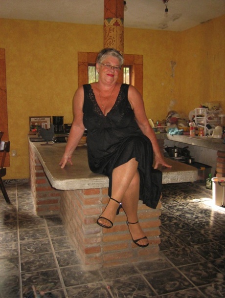 On an island in the kitchen, Fat oma Girdle Goddess strips to remove her tan pantyhose.