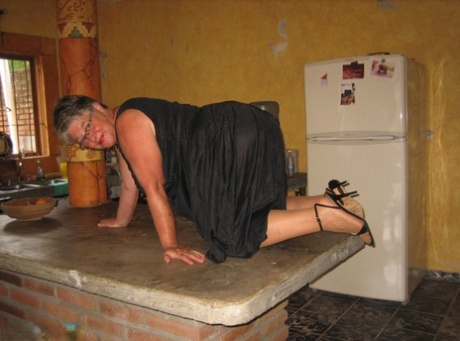 An island in the kitchen is where fat oma Girdle Goddess strips and put on her pantyhose to appear more tan.