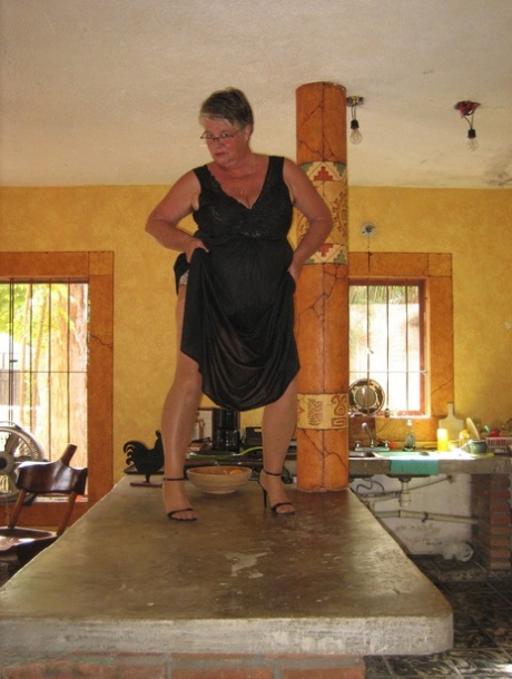 The Girdle Goddess, who is fat oma, strips herself stripping to tan pantyhose and puts them on on an island in the kitchen.