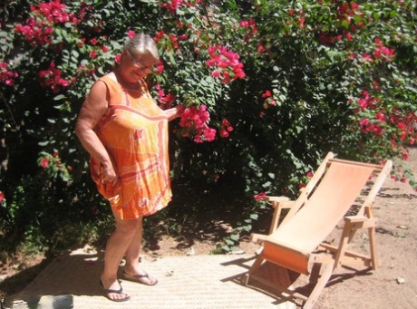 Obese granny, Goddess of the old garden shed her feet on the grass with her sandals.