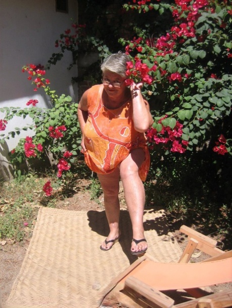 Oasis of the Obsessive Granny Girdle Goddess: She bare-chest on the garden patio while stripping.