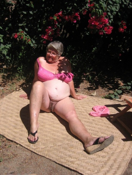 On the patio in a garden, the elderly lady known as "Old Lady" strips herself naked and puts on her sandals.