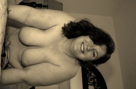 On her bed, an amateur BBW Inked Oracle is seen in a completely nude picture.