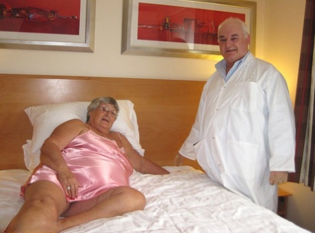 On her bed with her old doctor, Grandma Libby, who is elderly, engages in sexual activities.