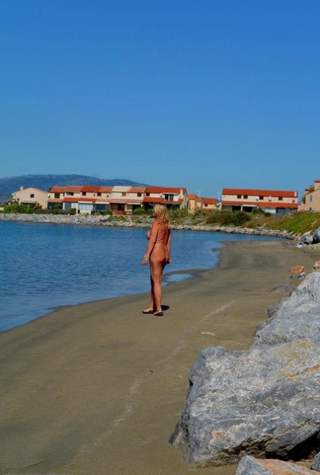 Crummelable, adult nude model Chrissy enjoys flaunting her large, oversized breasts while lounging on the beach.