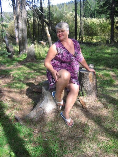 While in the woods, Fat Granny Girdle Goddess goes naked and removes her purple attire.
