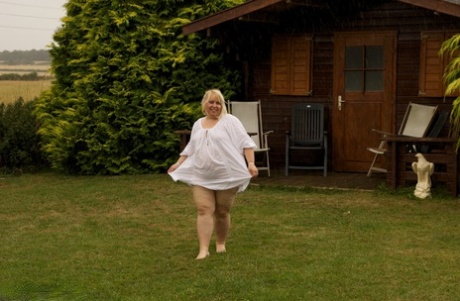 Despite her age, blonde-haired beauty Lexie Cummings shows off an obese body on the back lawn.