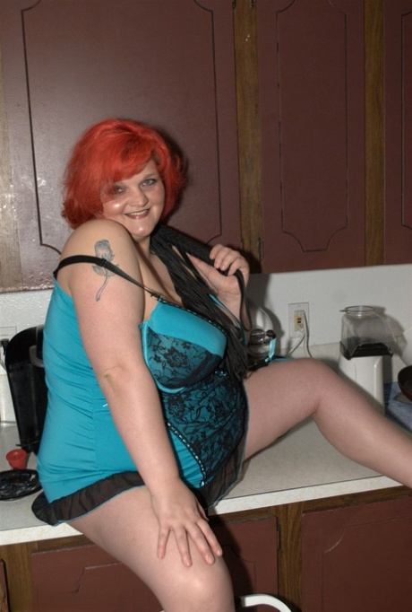 In her kitchen, the overweight redhead Black Widow AK enjoys playing with all of her big tits.