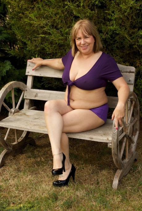 The older Speedy Bee, a UK amateur, is seen naked in heels on a garden bench.