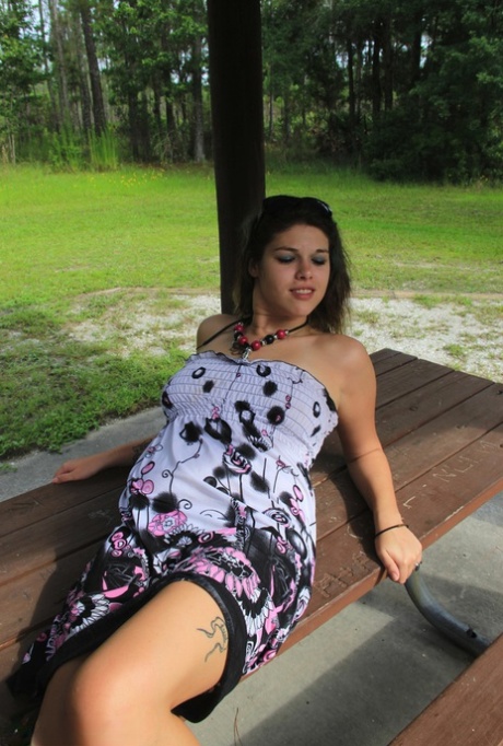 Outside on a picnic table, an overweight man is involved in gangbanging.