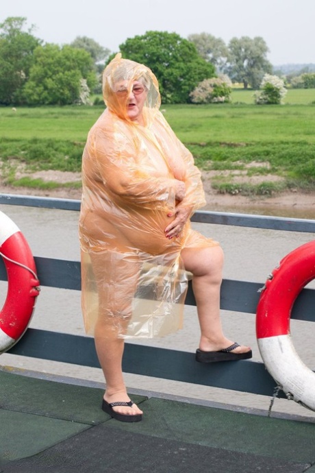 Big hair: Obese British amateur Grandma Libby toils off in her see-through raincoat which she casts back on.