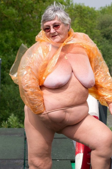 The overweight British amateur, Grandma Libby, takes off her transparent raincoat.