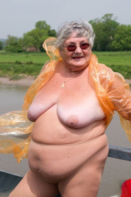 Grandma Libby, who is an obese British amateur, removes her raincoat that is transparent.