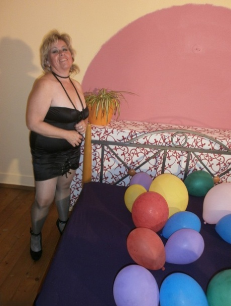 Горячая бабушка Каро в блестящих прозрачных колготках и на каблуках давит шарики на своей кровати