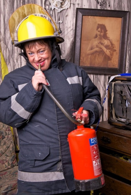 The aged fatty removes her firefighters attire to exhibit her twat in stockings.