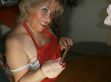 A wooden spoon and a cucumber are used by Horny Oma Caro to stimulate her pussy area.