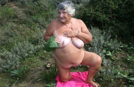 Grandma Libby, an obese British woman, exposes herself on a towel while being hit with dirt.