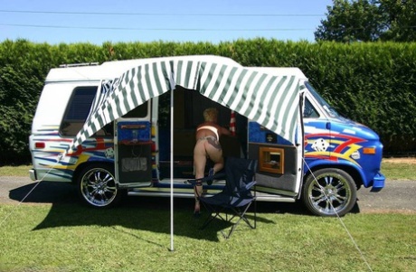 Exhibiting her large tits and pussy, Mary Bitch is photographed outside a B class camper van.