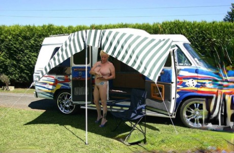 A young Mary Bitch, who is blonde at the age of 60, displays her large tits and pussy outside a B class camper van.