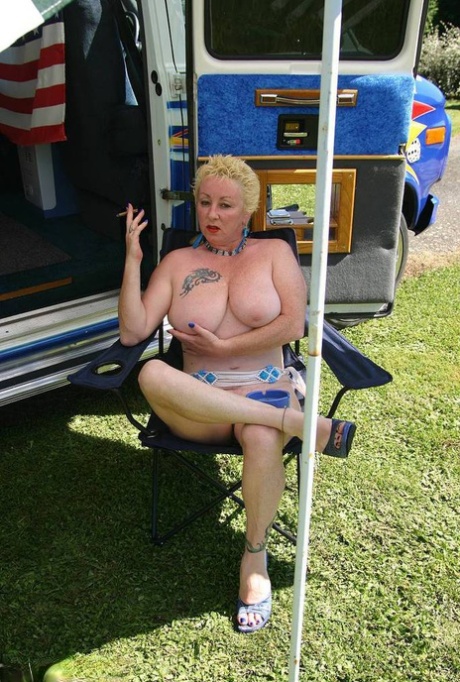 Mature blonde Mary Bitch shows her big tits and pussy outside a B class camper