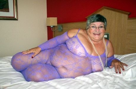 Grandma Libby, a British fat lady, masturbates on a bed while wearing a crotchless bodysuit.