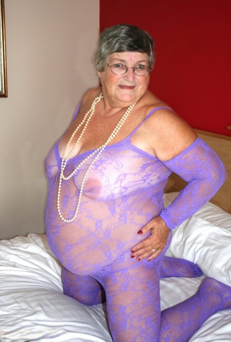 A crotchless bodystocking is used by Grandma Libby, a fat woman from Britain, to masturbate on a bed.