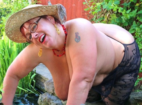 An aged fatty exposes her enormous chest through the use of an open-chested shirt and sunnies on her back.