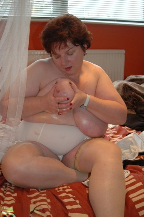 Prior to masturbating, Chris 44g from Britain uses her large breasts as a plaything.