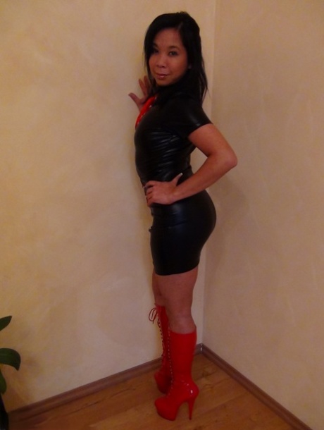 The sexiest Asian woman looks stunning in her hot latex and high-heeled boots that showcase flashes of seductive upskirts.