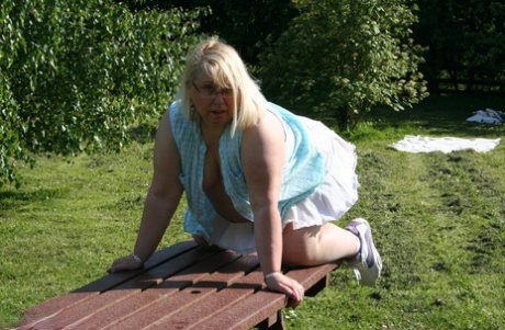 Stacking an orange on the picnic table, Lexie Cummings, who is now an elderly woman, displays it as a symbol of her maturity.