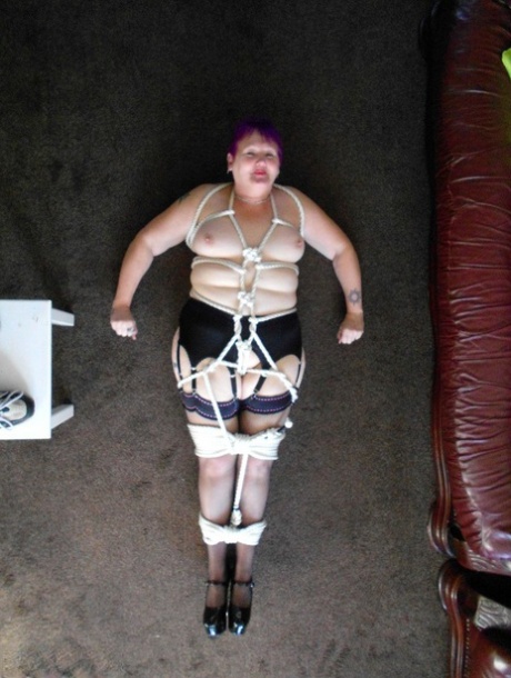 Dressed in garters and nylons, older BBW Valgasmic Exposed is tied up with rope.