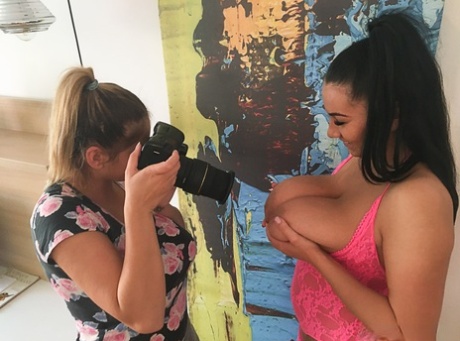 Uncovering her massive breasts, Erin poses for a lesbian photographer.
