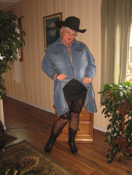 In boots and a cowgirl cap, Fat oma Girdle Goddess is seen stripping naked.