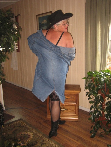 In a pair of boots and cowgirl hats, Fat Oma Girdle Goddess appears nude in this photo.