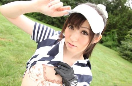 Superb-looking Japanese sports woman wearing a sporty top as she plays golf on the course.