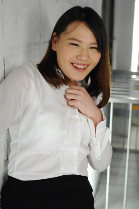 Aki Sasahara, a stylish Asian woman, wears a white blouse and black skirt.