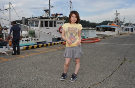 Young Japanese girl Miki Uemura poses on non nude in a skirt on a dock