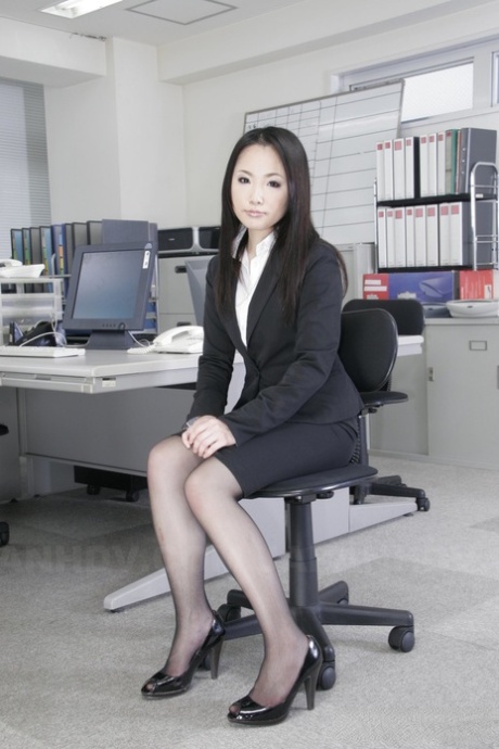 While at work, Japanese secretary Ai Mizushima models herself as if dressed in business attire.