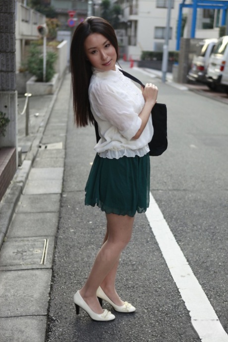 Standing in the street, Anna Sakura from Japan displays her radiant beauty.