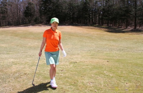 While lining up a putt, Nana Kunimi, a Japanese golfer, wears an unflattering no-frills outfit.