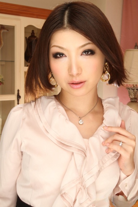 Tsubaki, the delightful Asian babe, poses in her charming attire before heading to work.