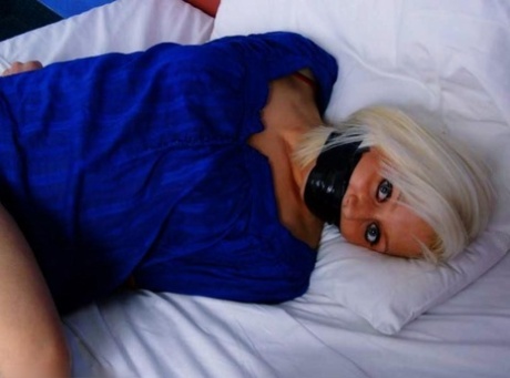 The platinum blonde is restrained with duct tape and silenced while sleeping on her bed.