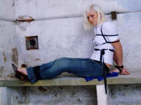 An American woman in blue jeans and white shirt is tied up and gagged.