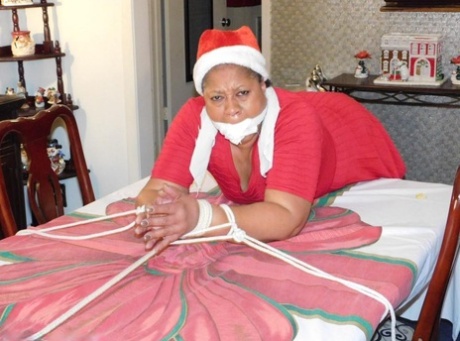 Ebony fatty is tied over a table at Christmas with her underwear showing