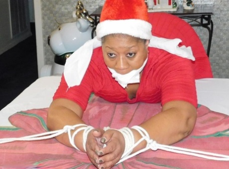 Ebony fatty is tied over a table at Christmas with her underwear showing