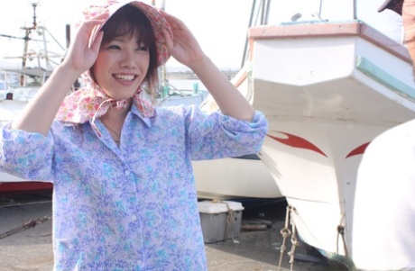 A Japanese girl wears a bonnet and rubber boots while masturbating in her pants.