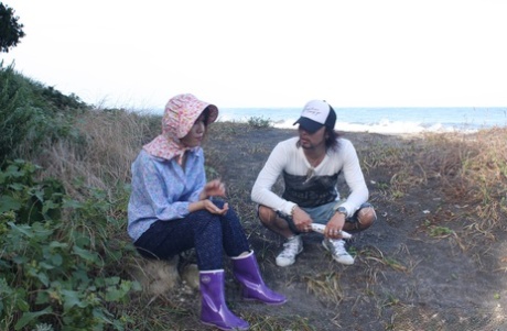 Wearing a bonnet and rubber boots, this Japanese girl is wearing her pants and masturbating.