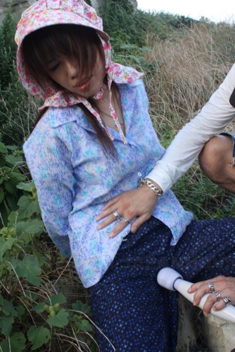 A Japanese girl is wearing a bonnet and rubber boots while masturbating in her pants.